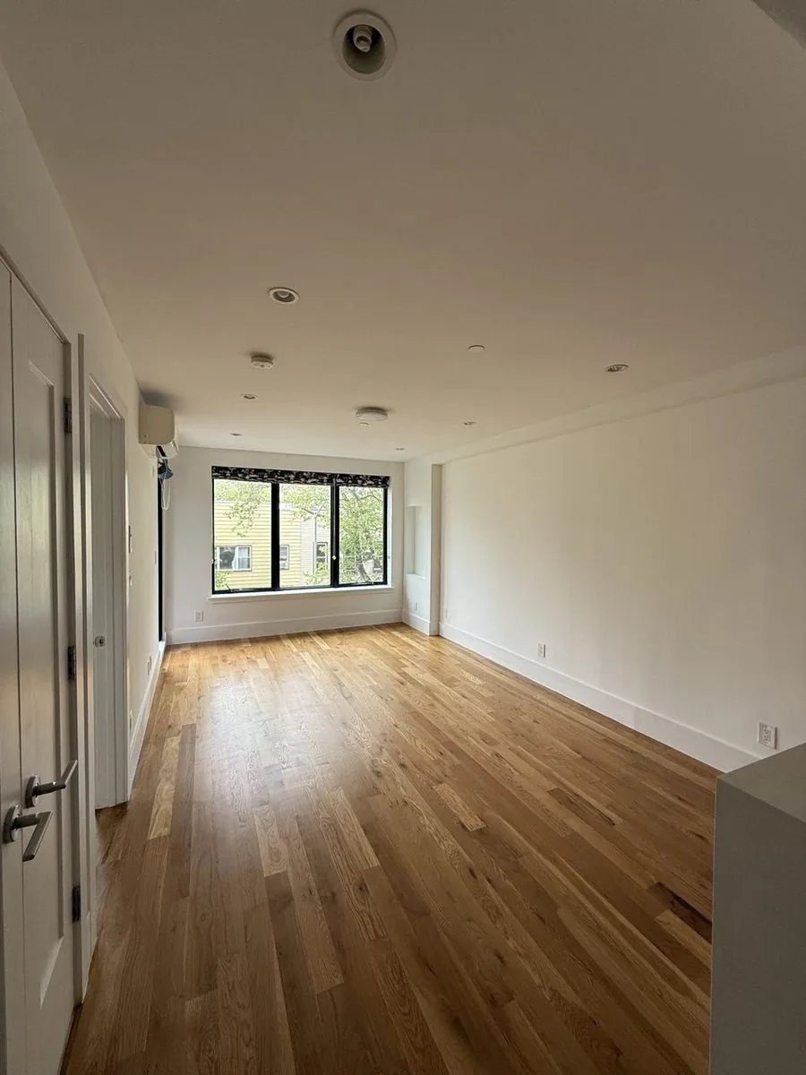 Bright empty apartment with white walls and wood flooring