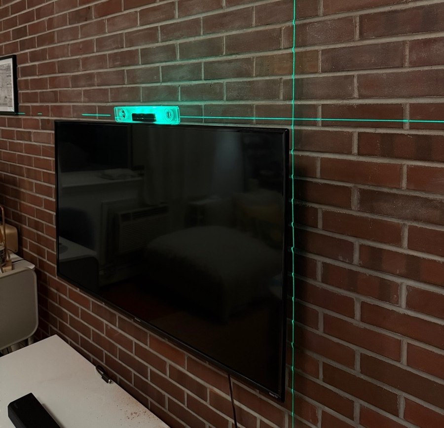 TV mounted on exposed brick wall in Brooklyn apartment — laser-leveled, $150 flat